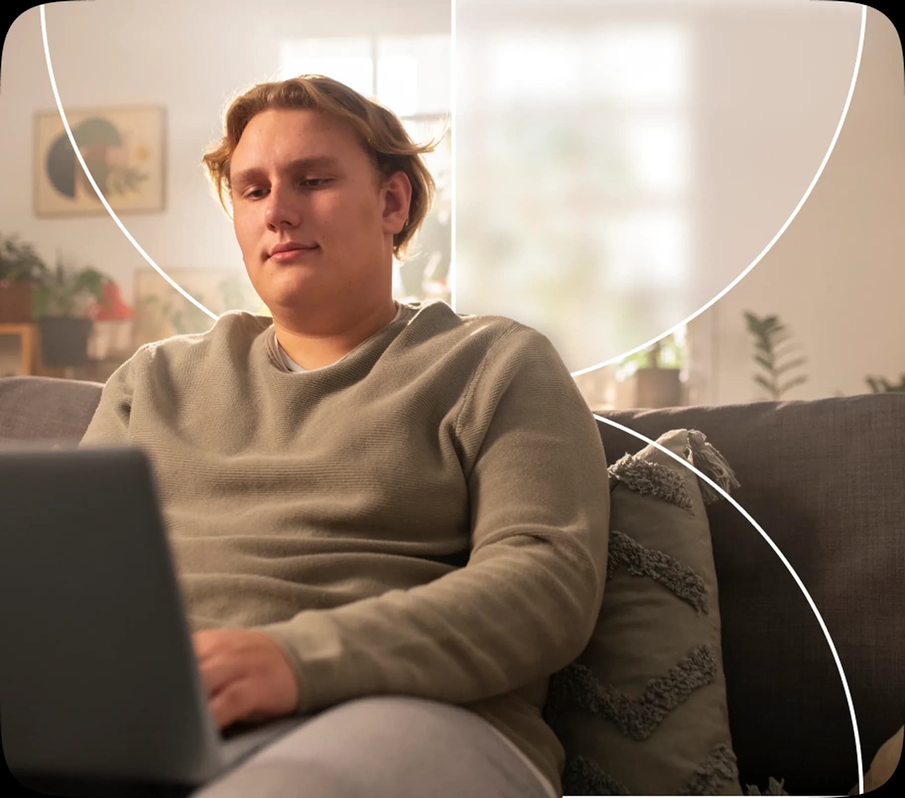 A young person relaxing on a couch with a laptop, reflecting accessible and comfortable care