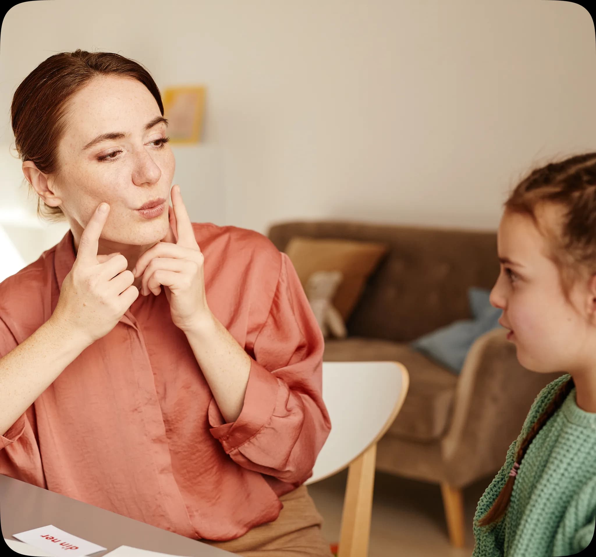A speech therapist working with a young patient in a warm, welcoming room