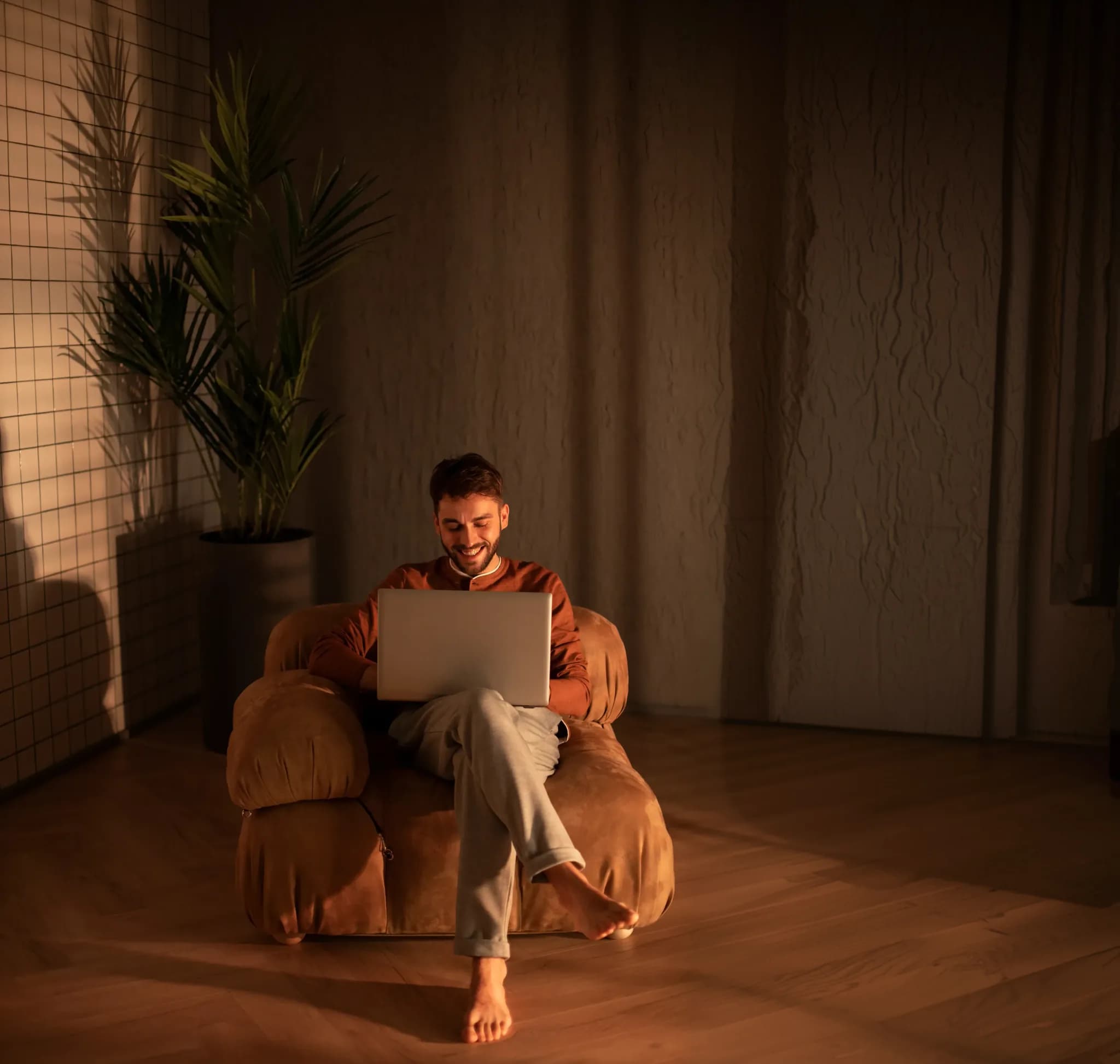 A person working on a laptop in a warm, relaxed setting
